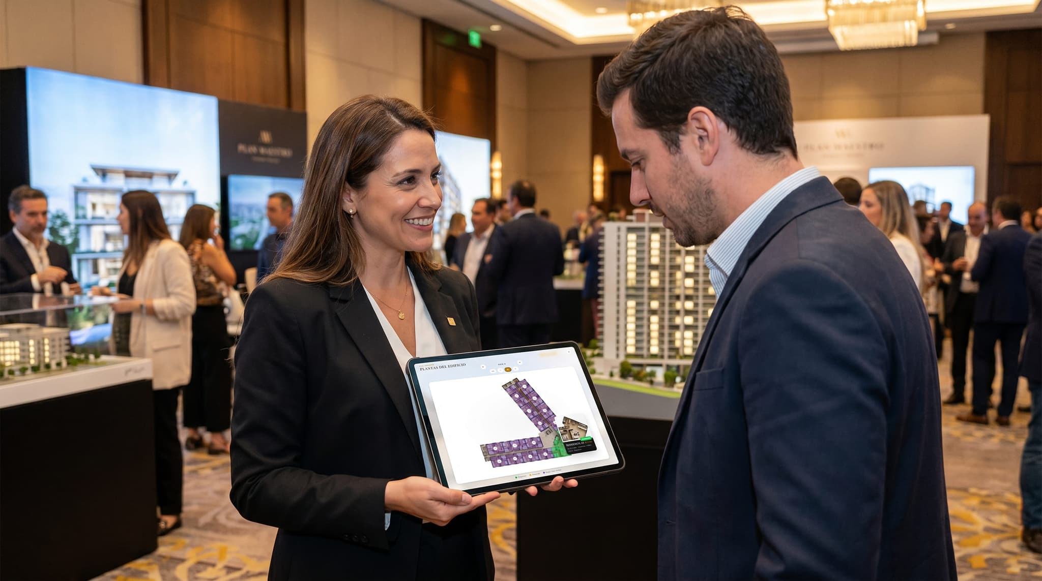 Asesora mostrando en una tablet las plantas interactivas del edificio durante una expo inmobiliaria