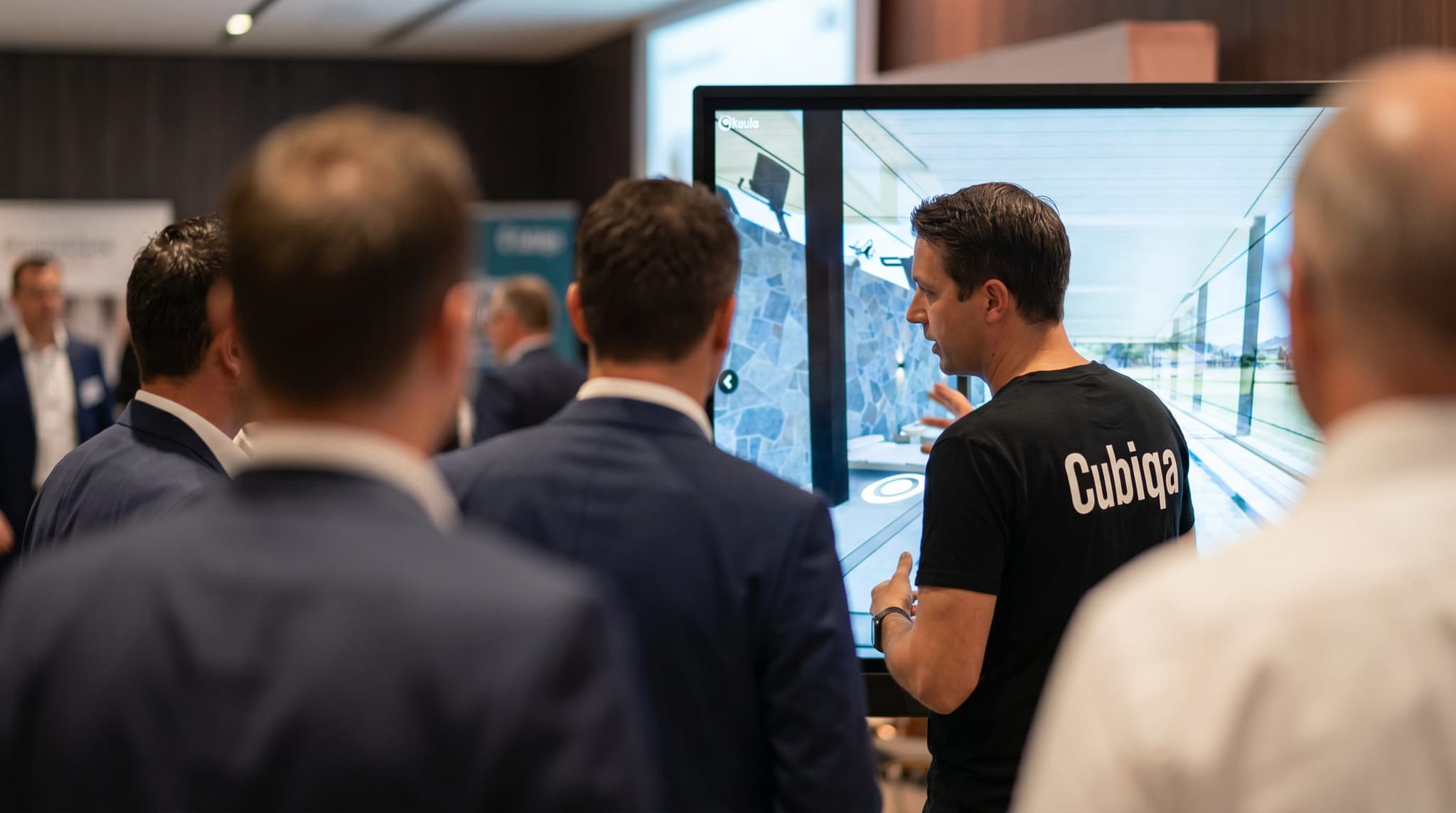 Equipo de CUBIQA operando un recorrido 3D en una pantalla táctil durante un evento con desarrolladores
